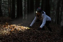 Beauty Tourist Woman With Headlight In The Forest At Dark