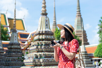 Wall Mural - Asian Girl Tourist is visiting Wat Pho or the Reclining Buddha Temple, one of the most-visited attraction in Bangkok, Thailand.