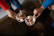 © Taras Grebinets - Top view of two children hands holding cups with cocoa and marshmallows