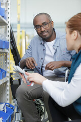 assistant helping a disabled customer in a hardware store