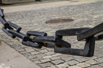 Large black chain on the background of the sidewalk..