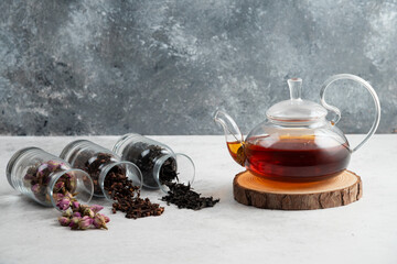 A glass teapot with tea on a wooden board