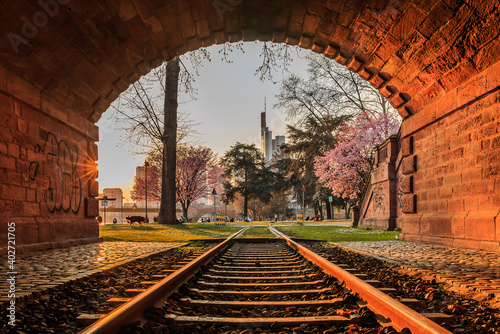 Tunnel with track at sunset with park on the bank of the river in Frankfurt. ...