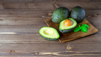 Wall Mural - Fresh ripe avocado on the wooden plate close up. Healthy vegetarian eating.