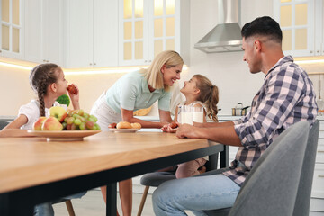 Sticker - Happy family eating together at table in modern kitchen