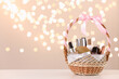 Wicker basket with cosmetics as present against blurred festive lights. Space for text