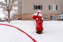Bright Red Fire Hydrant On The Roadside Of Community Covered With Snow In Winter