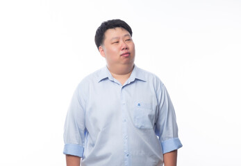 Wall Mural - Asian fat man in blue shirt thinking and looking to copyspace isolated on white background.