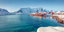 Panormic Winter View Of Popular Tourist Destination - Lofoten Islands. Red Houses On The Shore Of Norwegian Sea. Sunny Winter View Of Sakrisoy Fishing Village.  Landscape Photography..