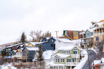 Canvas Print - Homes and road on residential neighborhood on snowy mountain against cloudy sky