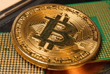 Wall Mural - Golden coin with bitcoin symbol on a mainboard. Bitcoin Virtual Cryptocurrenc or BTC concept