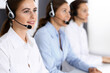 © rogerphoto - Call center. Group of operators at work. Focus on beautiful business woman in headset