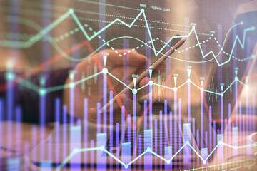 Double exposure of man's hands holding and using a phone and financial graph drawing. Analysis concept.