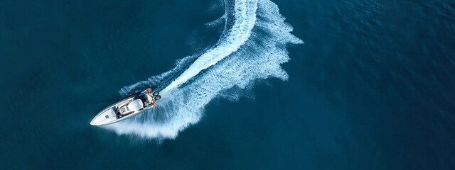 Wall Mural - Aerial drone top down ultra wide photo of inflatable power rib boat making extreme manoeuvres in Mediterranean bay with deep blue sea at dusk