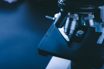 Laboratory equipment optical microscope, closeup of scientific microscope with metal lens, data analysis in the laboratory