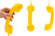 © Nikolay - Yellow handset in woman hand isolated on white.