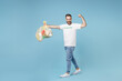 © ViDi Studio - Full length strong young man in volunteer t-shirt hold bags with plastic paper trash showing biceps muscles isolated on blue background. Voluntary free assistance help trash sorting recycling concept.