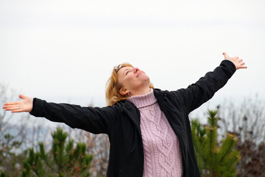 joyful woman with outstretched arms in nature