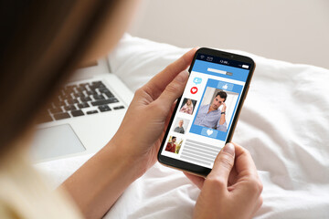 Poster - Young woman visiting online dating site via smartphone indoors, closeup