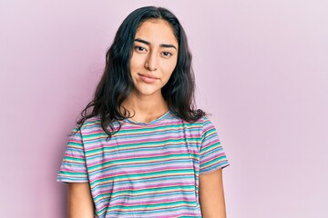 hispanic teenager girl with dental braces wearing casual clothes relaxed with serious expression on 