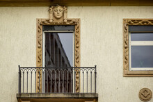 A Fragment Of A Building With A Wrought-iron Balcony And A Bas-relief