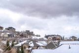 Fototapeta Do pokoju - Mountain homes on a cold snowy setting beneath gray overcast sky in winter