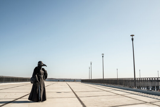 plague doctor alone on a large paved area