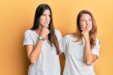 Poster - Hispanic family of mother and daughter wearing casual white tshirt thinking worried about a question, concerned and nervous with hand on chin