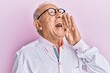 © Krakenimages.com - Senior caucasian man wearing casual clothes and glasses shouting and screaming loud to side with hand on mouth. communication concept.