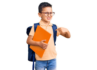 Wall Mural - Little cute boy kid wearing school bag and holding book pointing finger to one self smiling happy and proud