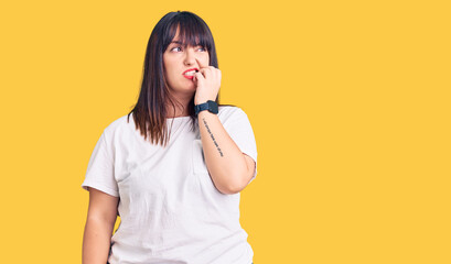 Sticker - Young plus size woman wearing casual clothes looking stressed and nervous with hands on mouth biting nails. anxiety problem.