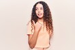 © Krakenimages.com - Beautiful kid girl with curly hair wearing casual clothes smiling with happy face looking and pointing to the side with thumb up.