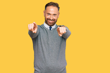 Handsome middle age man wearing business clothes pointing to you and the camera with fingers, smiling positive and cheerful