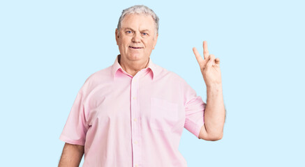 Canvas Print - Senior grey-haired man wearing casual clothes smiling with happy face winking at the camera doing victory sign. number two.