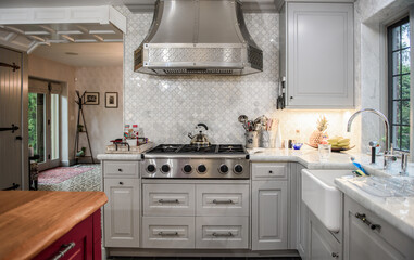 contemporary kitchen with gray, white and maroon colors and stainless steel stove and hood.