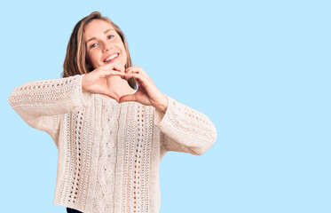 Sticker - Young beautiful blonde woman wearing casual sweater smiling in love doing heart symbol shape with hands. romantic concept.