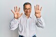 © Krakenimages.com - Middle age indian man wearing casual clothes and glasses showing and pointing up with fingers number nine while smiling confident and happy.