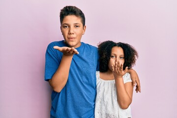 Canvas Print - Young hispanic family of brother and sister wearing casual clothes together looking at the camera blowing a kiss with hand on air being lovely and sexy. love expression.