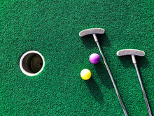 Mini Golf Clubs And Balls On Putting Green Artificial Grass Carpet