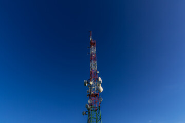 Broadcast wireless signal transmission tower in the background of blue sky and white clouds.