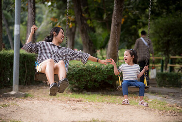 Asian kid are having fun with their mothers in the form of a vacation in the park.Mother's love concept, selective focus