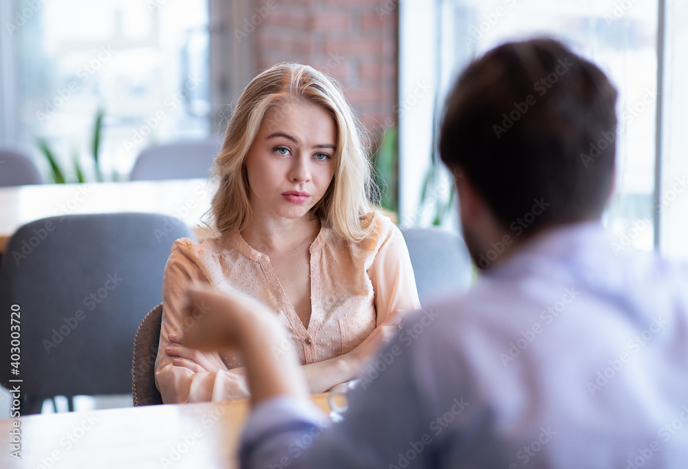Bad date. Young woman feeling bored during dinner at cafe, unhappy with her boyfriend, disinterested in conversation