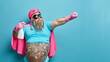 © wayhome.studio  - Serious bearded fatso man dressed in superhero costume holds detergent stretches arm as if going to fly has big tattooed belly poses against blue studio background copy space for your information