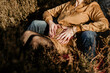 © Nander - Pregnant Couple With Hands on Pregnant Belly Sitting in A Field