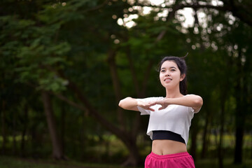  Asian woman is warm up, To make the muscles flexible Before going to jogging for good health and energy metabolism,Outdoors cross training workout. Healthcare concept