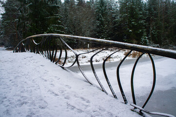 Beautiful old bridge over the icy river on winter evening