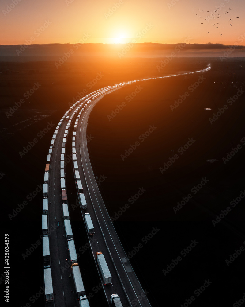 Aerial drone shot of a big traffic jam of Trucks that wait in line for border crossing control from the United Kingdom to France on the M20 before Dover - obrazy, fototapety, plakaty 