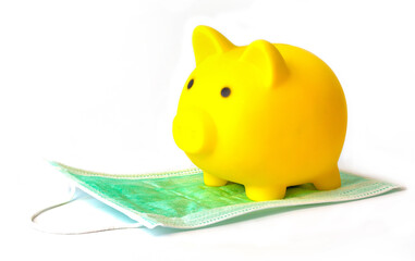 Business protection idea from covid-19, yellow pig piggy bank on mask on white background.