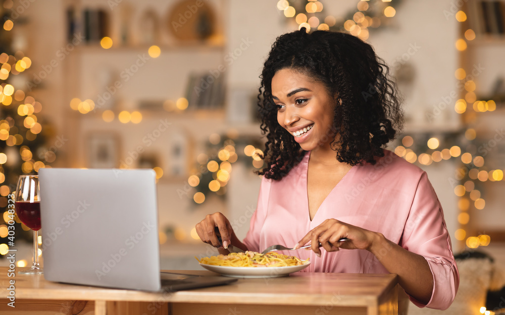 Black woman having dinner during virtual date on laptop - obrazy, fototapety, plakaty 