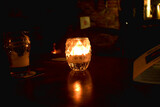 Fototapeta  - Candle light in glass jar on table decorated in dark night Candle light in glass jar on table decorated in dark night